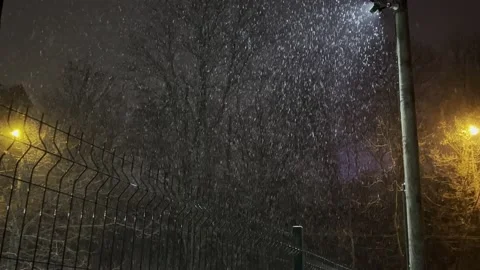 Snow on a background of light lanterns at night Video stock 166177744