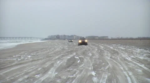 Snow on beach, trucks passing Stock Footage 24454012