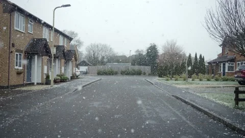 Snow begins to fall on empty housing estate street in England. Stock Footage 145921310
