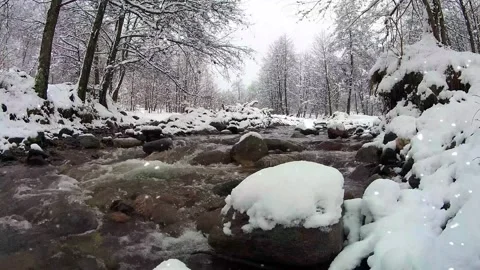 Snow Begins To Fall Over Stream in Rocky Winter Gorge Stock Footage 325329148
