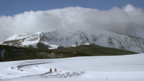 Snow bikers cruising down a mountain trail Stock Footage 113265067