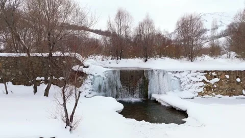 Snow blankets quiet winter forest with rocky stream Stock-Footage 332367228