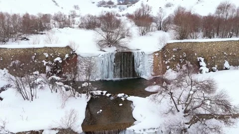 Snow blankets quiet winter forest with rocky stream 스톡 동영상 332367387