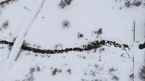 Snow blankets quiet winter forest with rocky stream Stock-Footage 332367645