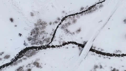Snow blankets quiet winter forest with rocky stream 스톡 동영상 332367782
