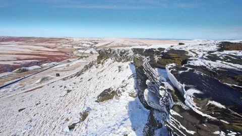 Snow blankets rocky cliffs under clear blue sky Vidéo 347272184