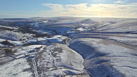 Snow blankets rolling hills under bright blue sky Vidéo 347260692