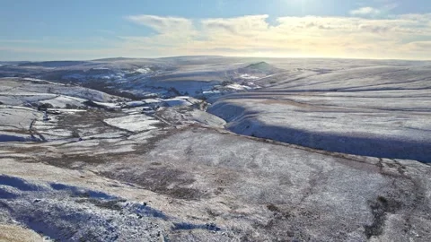 Snow blankets rolling hills under clear blue skies Vídeo Stock 347263223