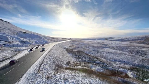 Snow blankets rolling hills under a bright sky Vidéo 347270176