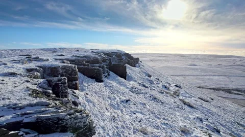 Snow blankets rugged cliffs under a bright, clear sky 库存影片 347270828