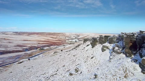 Snow blankets rugged cliffs under clear blue skies Vidéo 347271210