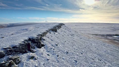 Snow blankets rugged rocks under a clear blue sky Stock-Footage 347270617