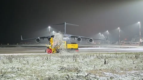 Snow blower passing by a boeing c-17 globemaster Stock Footage 168243276