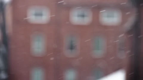 Snow blowing sideways with a brick building in the background Stock Footage 268621483