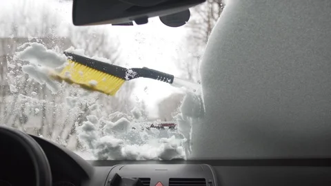 Snow brush removing snow from the windshield, view from inside the car Stock Footage 101351057