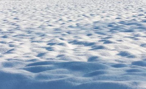 Snow bumpy ground with light and dark areas 스톡 사진