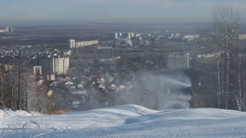 Snow cannon preparing a slope to ski in the background of the urban landscape Видео 144194687