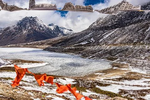 Snow cap mountain with dramatic sky through the blurred buddhism flags frame  Foto stock