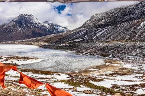Snow cap mountain with dramatic sky through the blurred buddhism flags frame  Photos