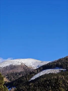 Snow-Capped Alpine Mountain Peak Against Clear Blue Sky Фото