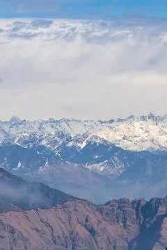 Snow capped himalayas mountain range with cloudy sky Fotos de archivo