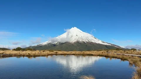 Snow-Capped Mount Taranaki Reflected in Still Water Stockbeeldmateriaal 337473152