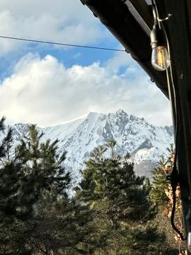 Snow-capped mountain cliffs under a blue sky in sunny weather Stock Photos