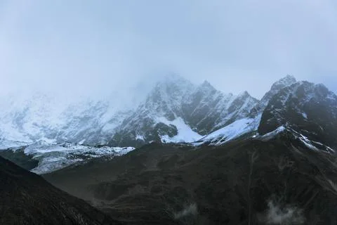 Snow-capped mountain in cloudy sky Stock Photos