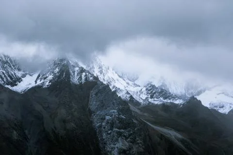 Snow-capped mountain in cloudy sky Stock Photos