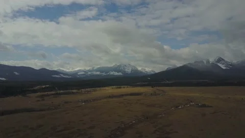Snow capped mountain drone push in with green fields below Vídeos de archivo 167563231