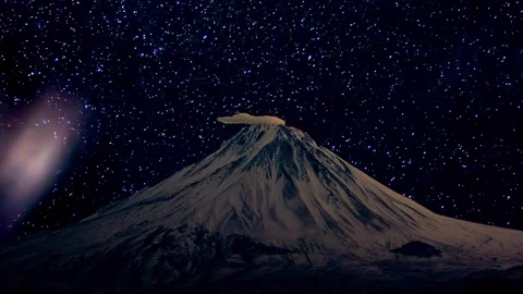 Snow-capped mountain peak with a cap cloud under a starry night sky Stock Footage 347864879