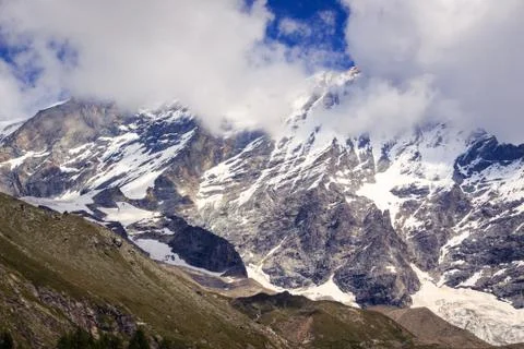 Snow capped mountain peak in clouds Stock Photos