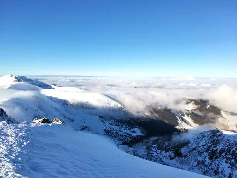Snow capped mountain peak surrounded by clouds Stock Photos