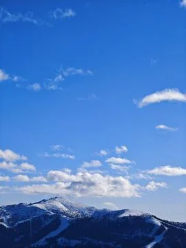 Snow-Capped Mountain Peak Under a Vibrant Blue Sky Фото