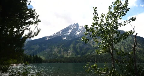 Snow-capped mountain peaks beside a peaceful alpine lake Stock-Footage 341432674