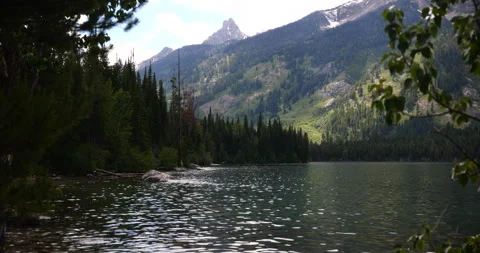 Snow-capped mountain peaks beside a peaceful alpine lake Stock Footage 341433929