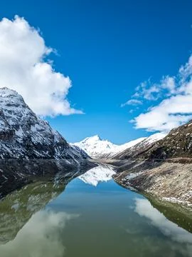 Snow-capped mountain peaks reflected in a calm alpine lake 스톡 사진