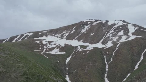 Snow-capped mountain peaks under cloudy sky Stock Footage 345388059