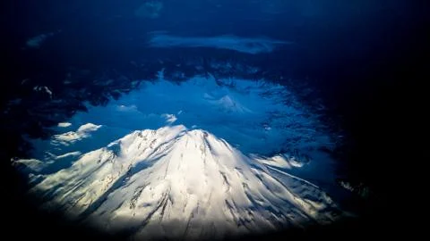 Snow capped mountain from plane window Stock Photos