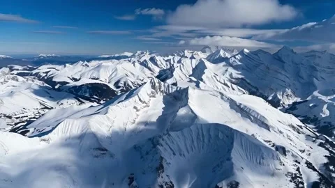 Snow capped mountain range against clear blue sky aerial view of winter won.. Stock Footage 321948179