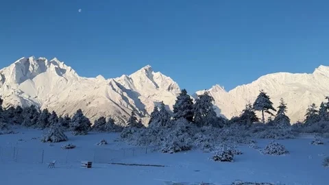 Snow Capped Mountain Range and Forest with Moon in Daytime 库存影片 332963483