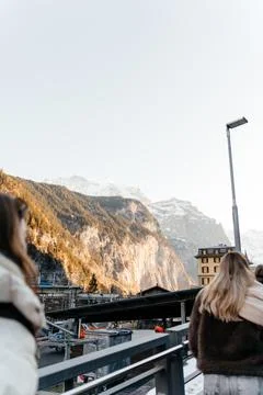 Snow capped mountain range rising above a peaceful rural landscape with green Stock Photos