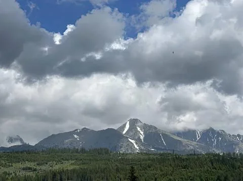 Snow-capped mountain range under cloudy sky in nature Stock Photos