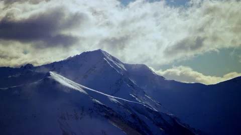Snow capped mountain with shade and sun patches Stock Footage 159717926