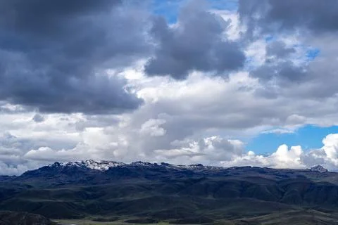 Snow-capped mountain under dark storm clouds in the Peruvian highlands Stock Photos