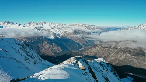 Snow capped mountains above clouds in a blue sky in sunny weather Stock Footage 138035544