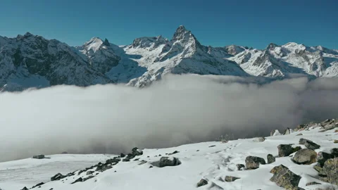 Snow capped mountains above clouds in a blue sky in sunny weather Stock Footage 138036047
