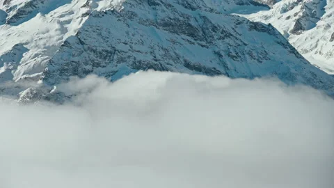 Snow capped mountains above clouds in sunny weather Stock Footage 138038822