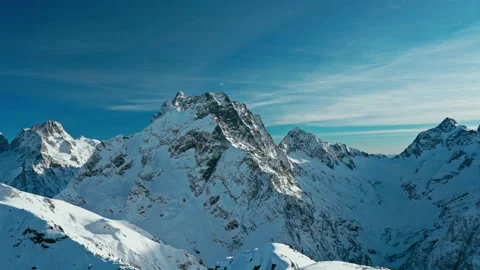 Snow capped mountains with clouds in a blue sky in Sunny weather Stock Footage 138035396