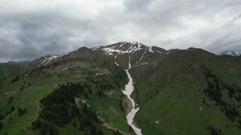 Snow-capped mountains with green valleys and cloudy sky in scenic landscape Stock-Footage 340392845